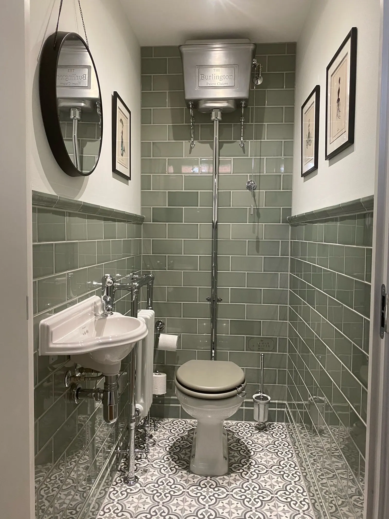 Grey metro-tiled cloakroom with a wall-hung basin, WC and mirror.