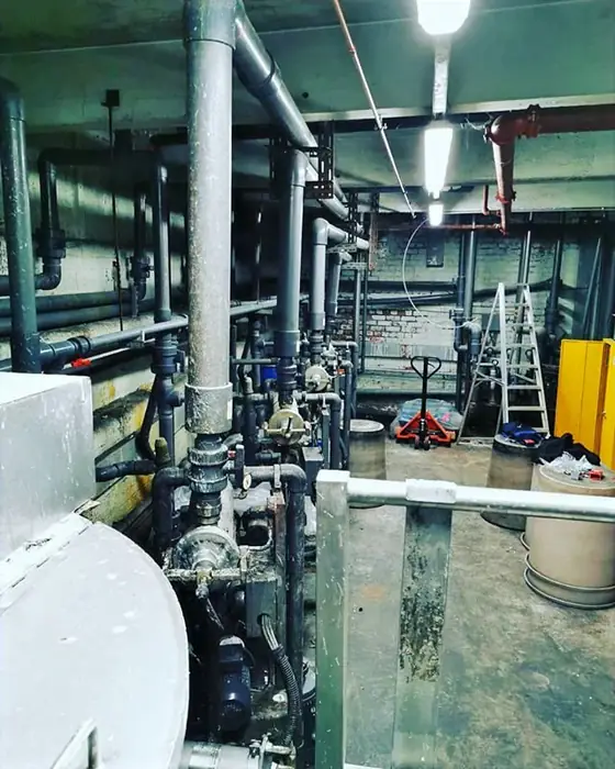 Commercial plant room with insulated pipework, valves and pumps.